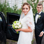 Groom and bride near wedding car